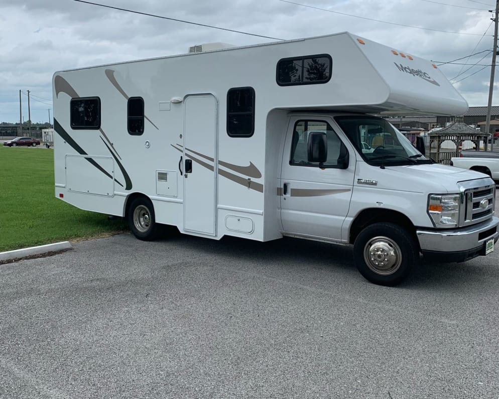 If there is flat ground behind RV, it will fit in a standard parking spot.