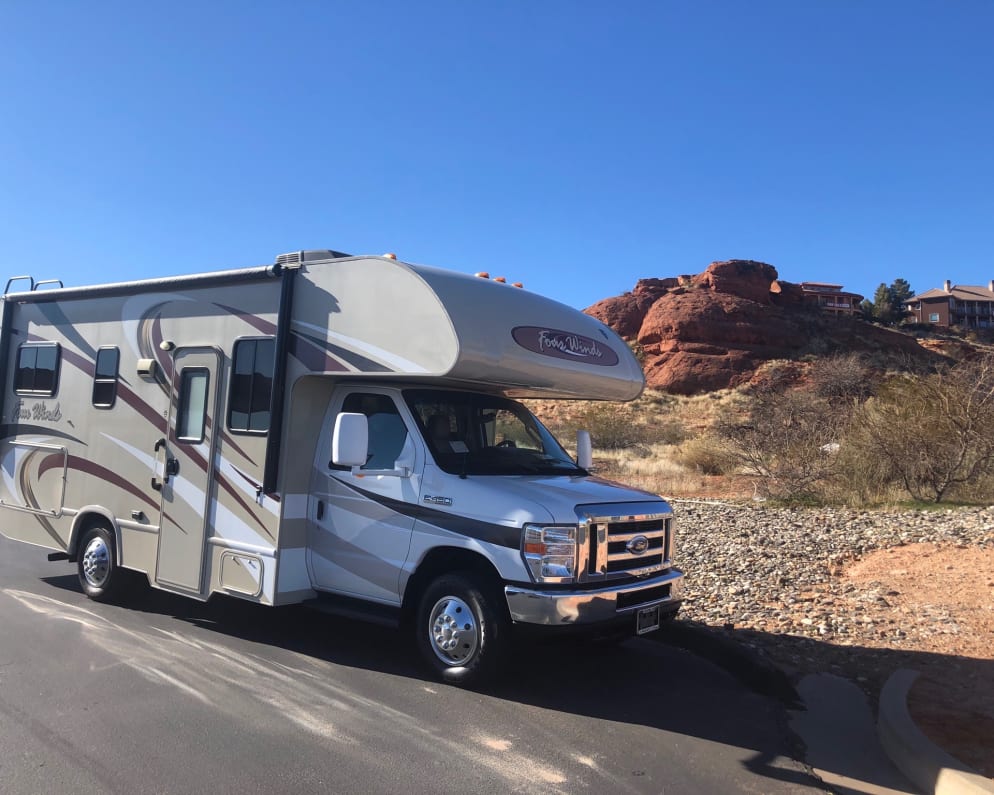 outside of motorhome with red rock and blue sky contrast 