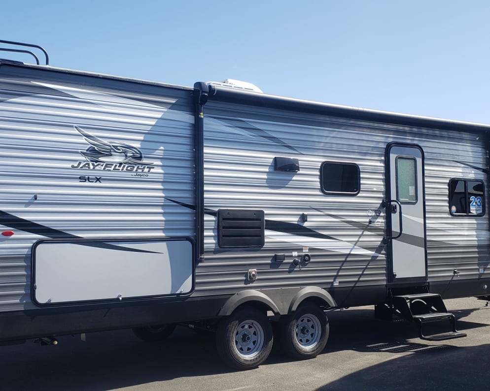 Passenger side, front door, awning, and outdoor kitchen. 