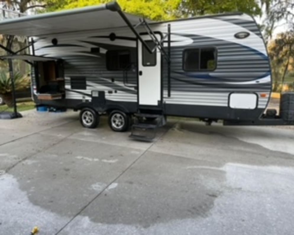 Exterior photo of camper and outdoor kitchen. 