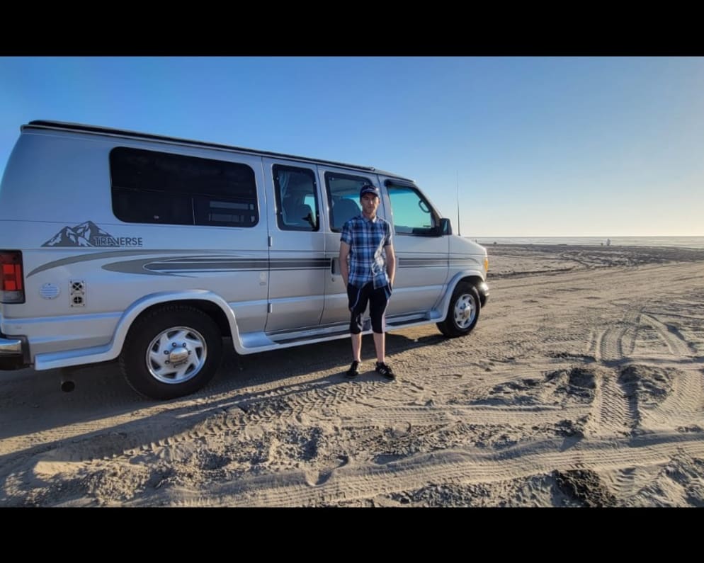 Oregon coast trip with the van parked on the beach.