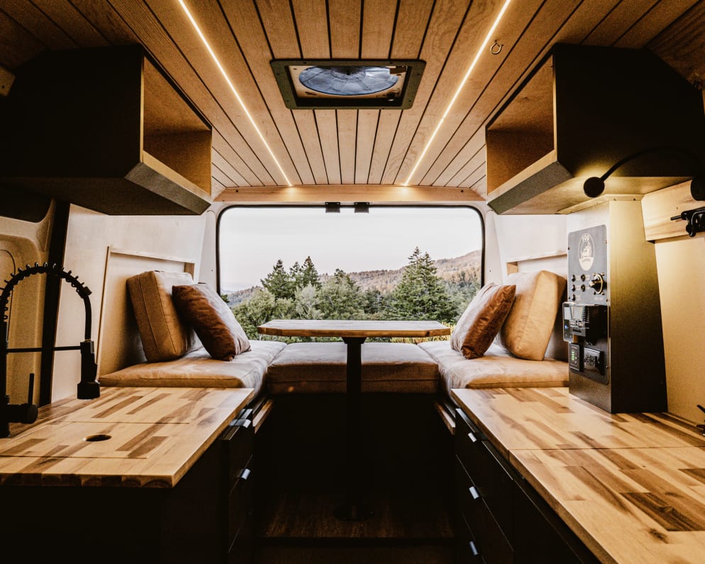 Immerse yourself in the luxury of simplicity within our camper van&#39;s interior, where clean lines, natural materials, and smart design converge to create a space that feels like home wherever the road takes you.