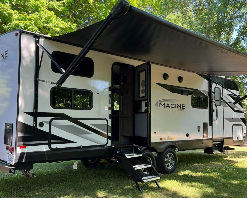 Travel trailer features two entrances with power awning.