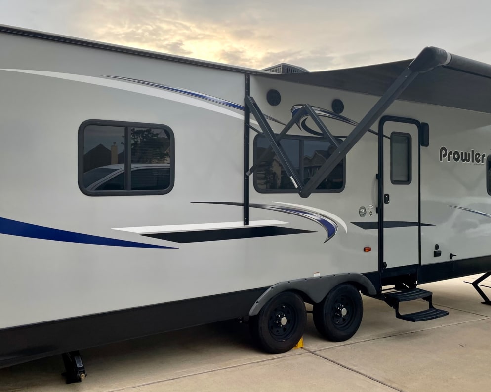 Exterior, with awning, steps, screen door, storage compartment for hoses etc. and speakers.