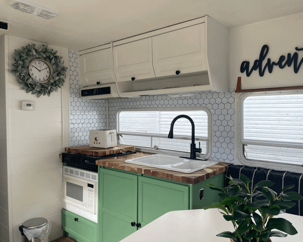 Kitchen has propane gas stove with 3 burners. There is a removable counter block for extra prep space. Plenty of storage above and below sink