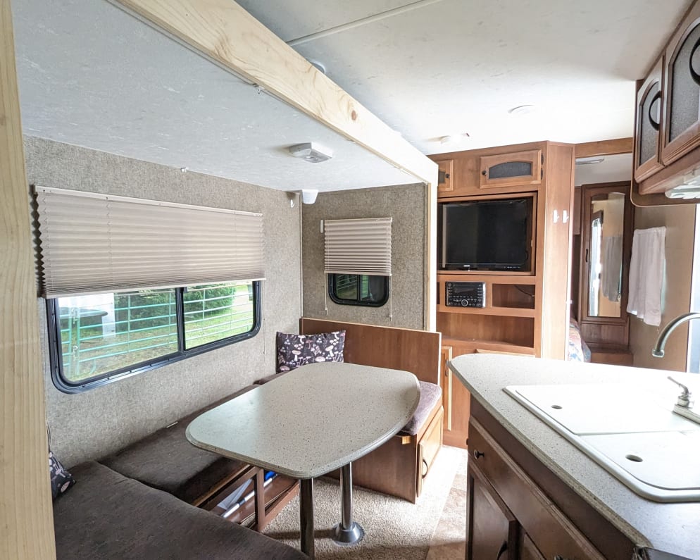 Standing next to the fridge, bunk beds on the same side as dining table. Slide out is in, additional 6&#39; x 10&#39; of floor space when out. Queen bedroom 