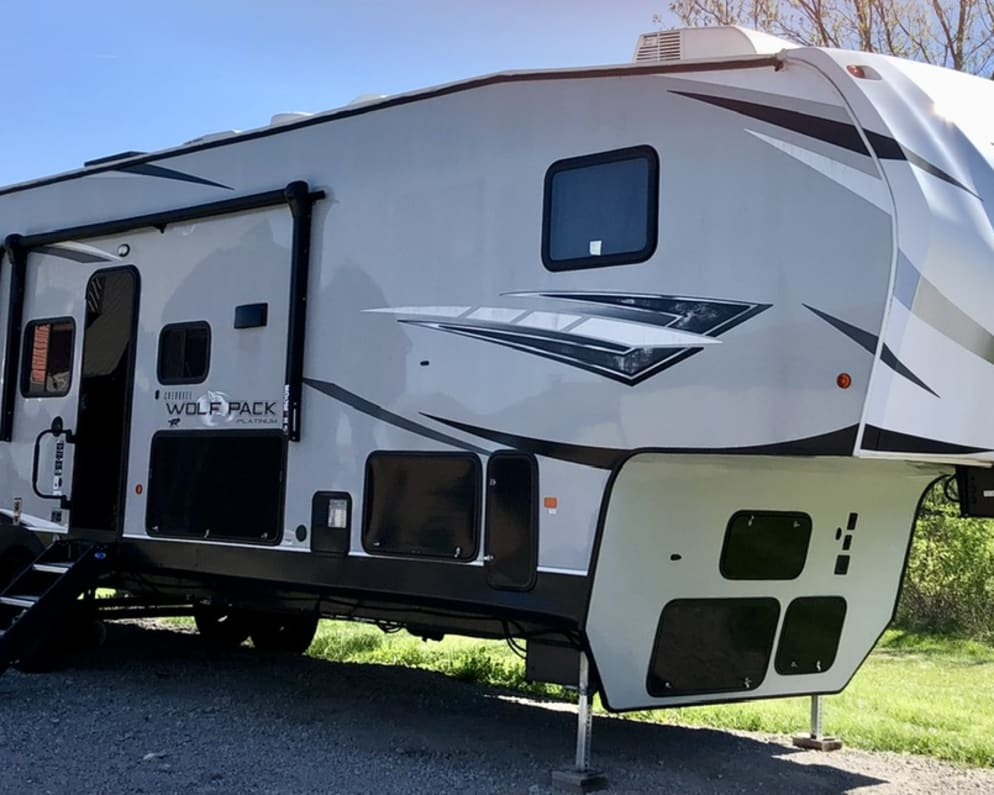 Outdoor space includes an ice maker and a small refrigerator near the first door. Two large power awnings to provide shade and shelter