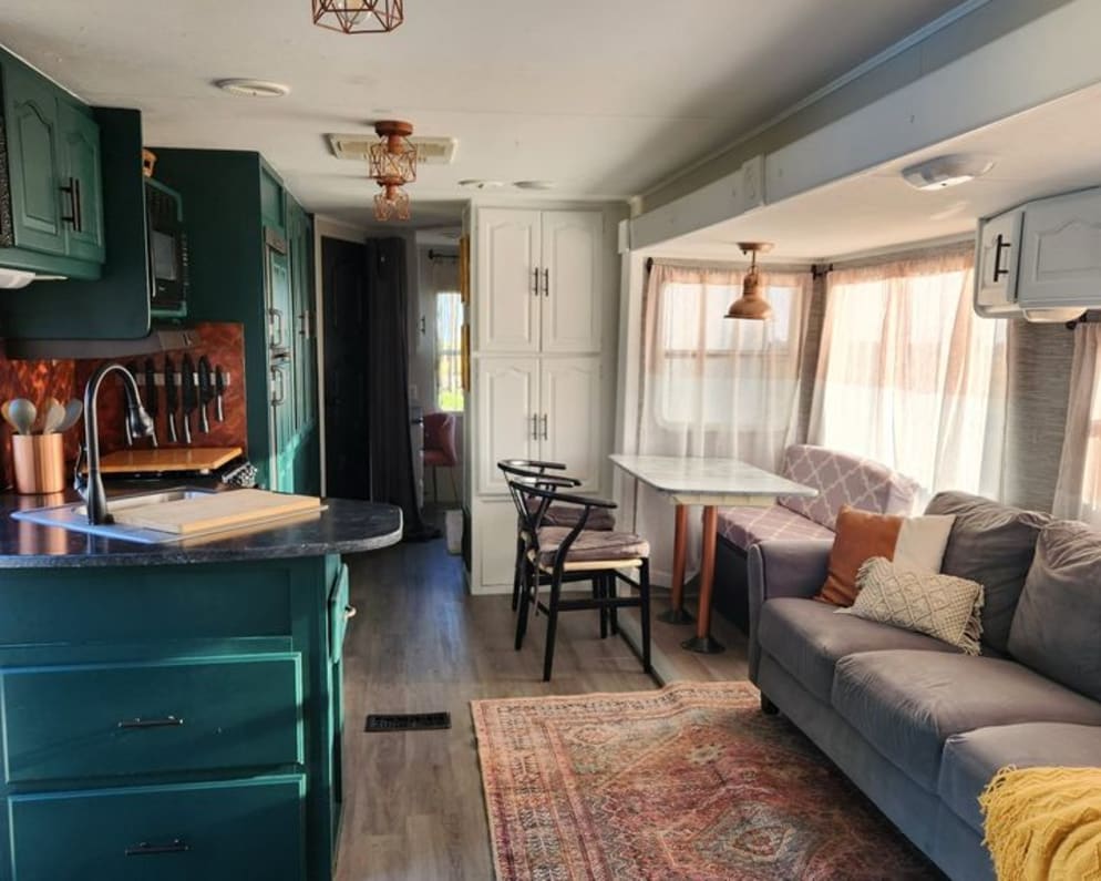 Interior of the RV with a couch, kitchen and dining area.