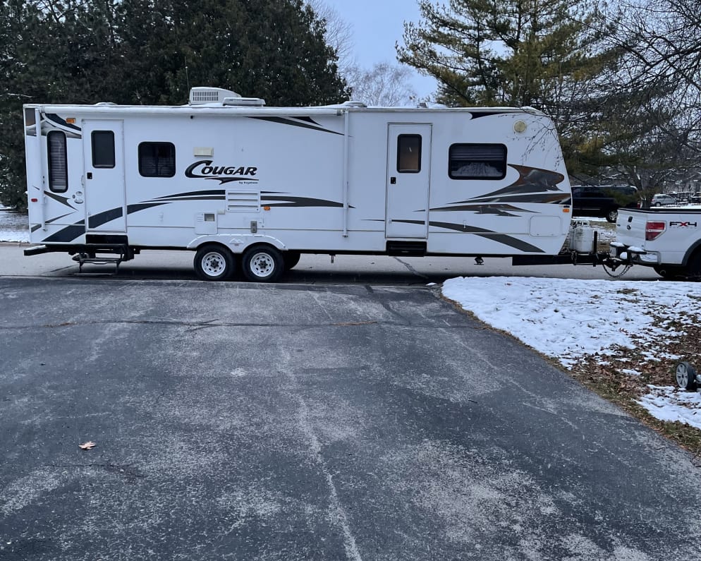 This camper has two slide outs on the back side with the two front doors. One accessed the kitchen, the other accesses  the bedroom. There is a massive closet in the bedroom and built in dressers for storage. 