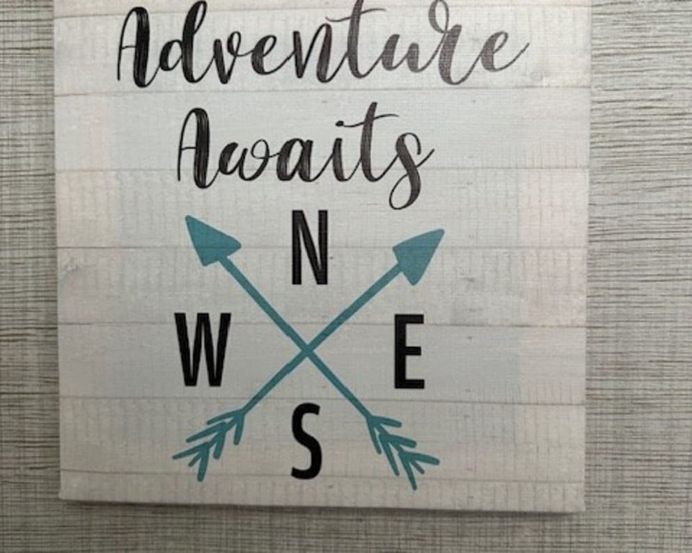 A "Adventure Awaits" sign