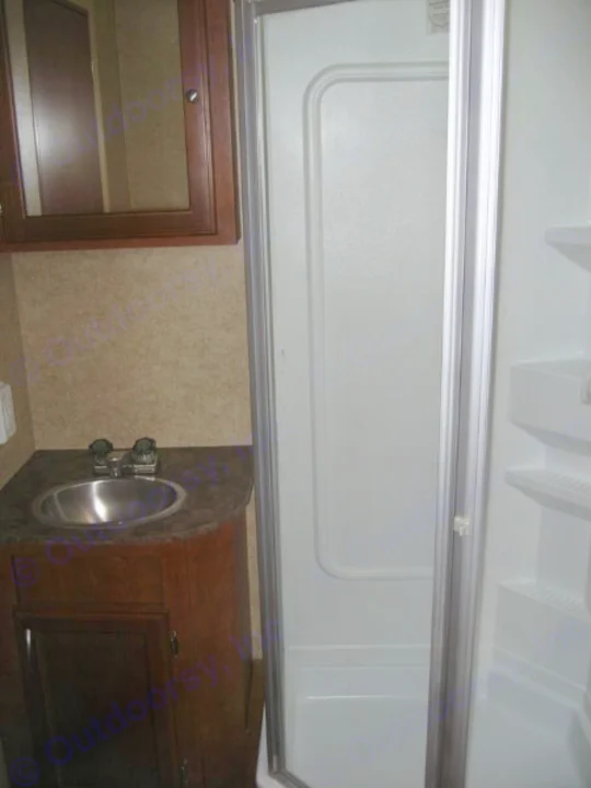 RV rental interior: functional bathroom featuring a sink, vanity, and bright shower stall with glass door.. Eclipse Milan 2011