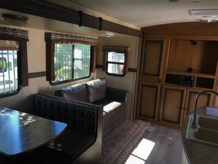 Spacious RV rental interior with dinette, sofa, and kitchenette, perfect for travel.. Radiance 28BHIK 2016