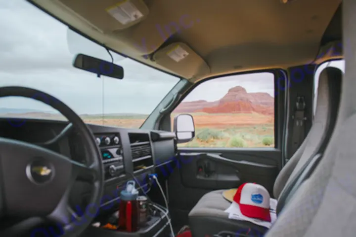 Van interior of an RV rental, showcasing vast desert and majestic red rock formations outside. Adventure awaits!. Chevrolet Express G1500 AWD 2014