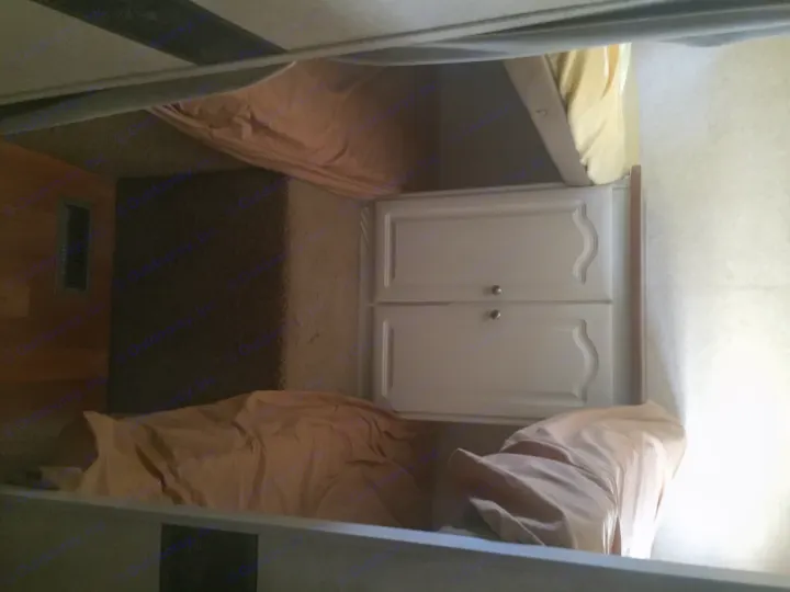 RV rental interior: A compact sleeping area featuring upper and lower bunk beds on each side, with a central white cabinet.. Keystone Outback 2007