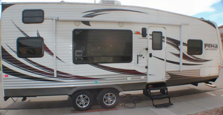 Exterior side view of a white Puma Unleashed travel trailer, ready for your next rv rental adventure.. Palomino Puma Unleashed 2013