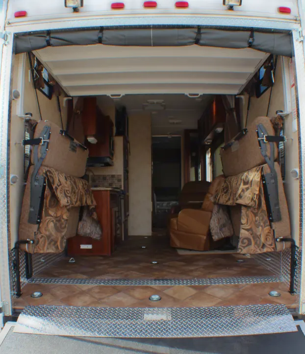 Inside this RV rental toy hauler: rear ramp access, fold-up beds, kitchen, and comfy chairs, ideal for adventure.. Palomino Puma Unleashed 2013