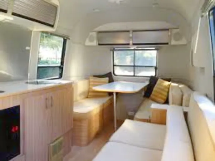 Spacious, modern Airstream travel trailer interior, ideal for your next RV rental adventure. Features a comfortable dinette and couch.. Airstream Safari 2008
