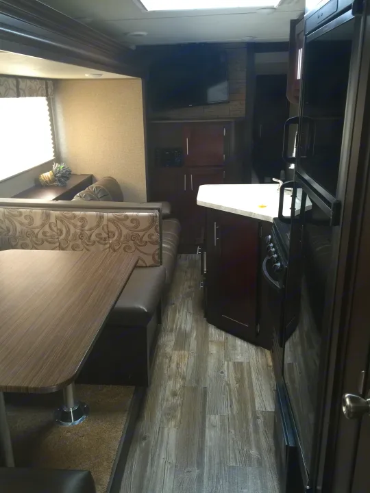 RV rental living space: comfy dinette, modern kitchen, and TV setup for your next adventure.. Forest River Cherokee 2017