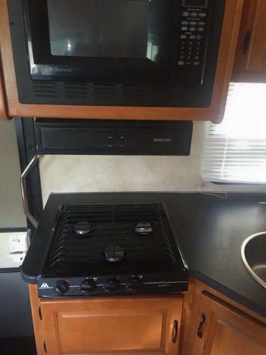 A compact RV kitchen: Dometic microwave, Wedgewood Vision stove, Ventline. Ford Majestic 23A 2012