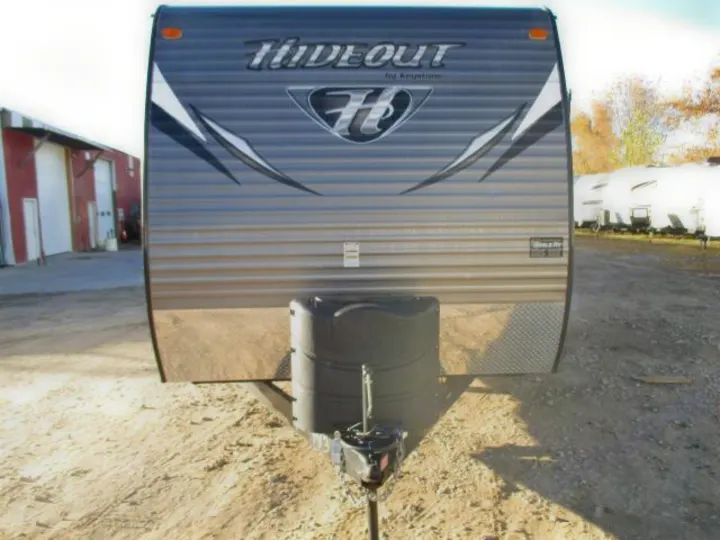 Front view of a gray travel trailer, branded 'Hideout by Keystone,' parked outdoors. It's equipped for towing, ideal for an rv rental.. Keystone Hideout 2014