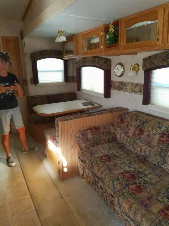 RV rental interior: patterned dinette, comfortable sofa, and overhead storage define this cozy camper living space.. Forest River Cedar Creek Silverback Edition 2005