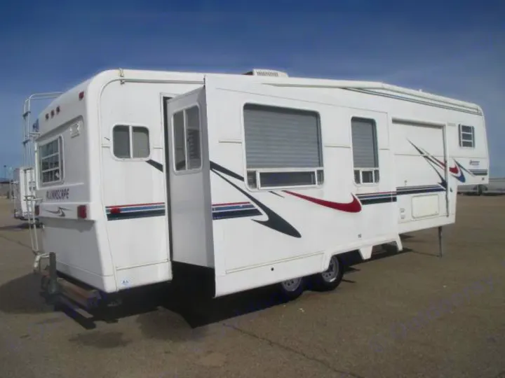 White RV rental with an extended slide-out, parked outdoors. See this spacious Alumascape RV for your next adventure.. Holiday Rambler Alumascape 2002