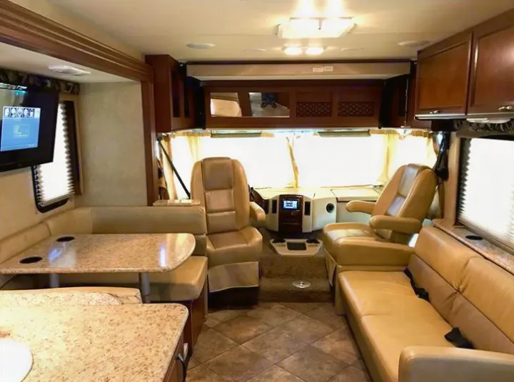 Spacious RV rental interior with dinette, sofa, and cockpit, ideal for comfortable travel.. THOR A.C.E 30.2 2015