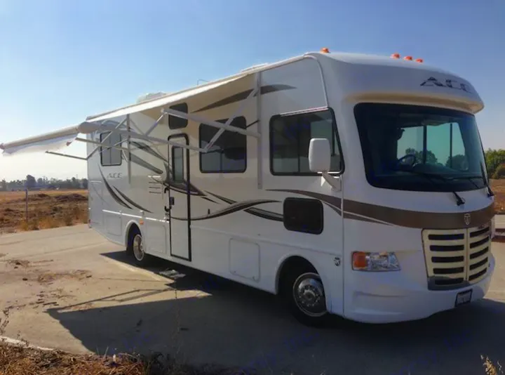 White ACE RV rental parked outdoors with its awning extended, ready for a road trip adventure.. THOR A.C.E. 29.1 2012