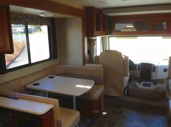 Inside this RV rental, see the spacious dinette by the window and the well-equipped cockpit. Ideal for travel.. THOR A.C.E. 29.1 2012