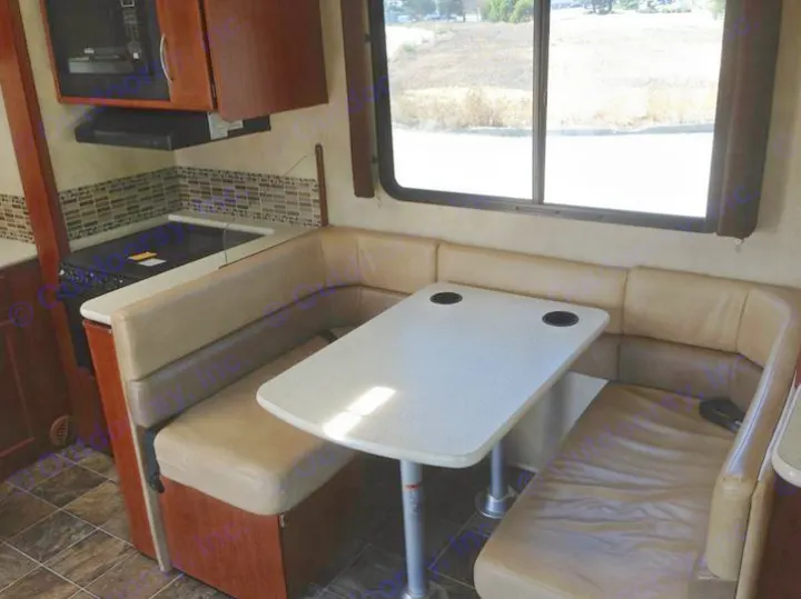 RV rental: U-shaped dinette with table, compact kitchen w/ stovetop, microwave, cabinets. Window view.. THOR A.C.E. 29.1 2012