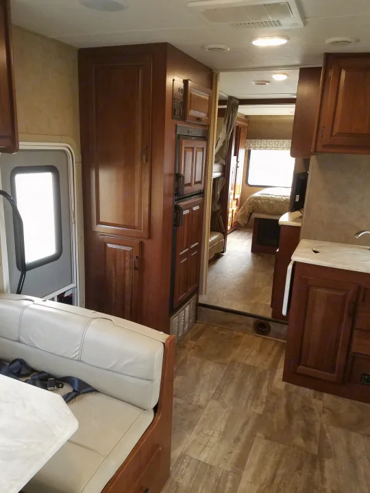 Spacious RV rental interior with dinette, kitchen, and a separate rear bedroom for comfortable travel.. Forest River Sunseeker 2017