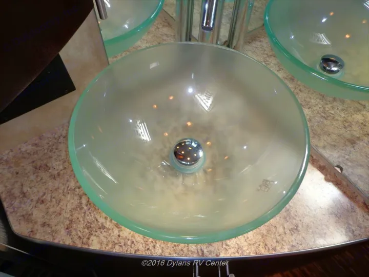 Modern glass vessel sinks on a speckled counter in an RV rental bathroom, a stylish feature for your next adventure.. Coachmen Prism 2009