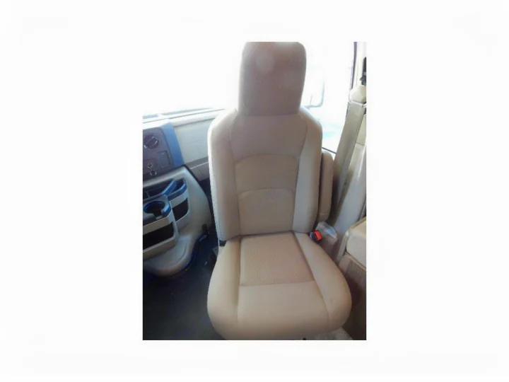 View of a beige passenger seat with armrests in an RV rental interior, showing dashboard controls & cup holders.. Coachmen Freelander 2017