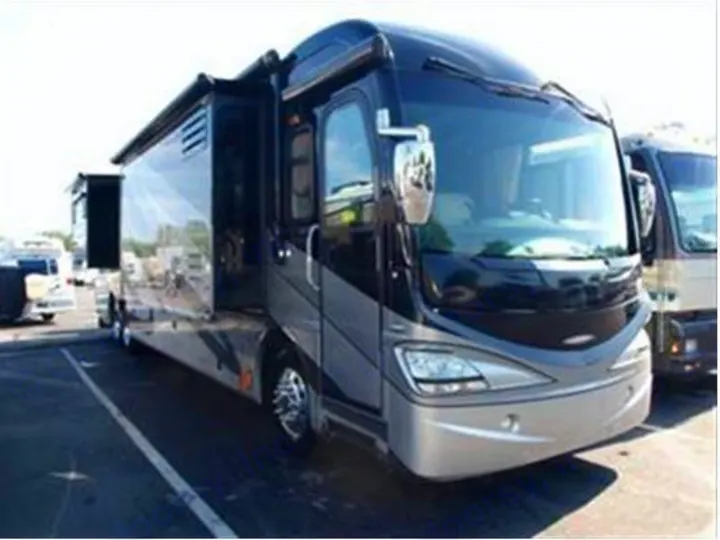 A sleek, modern Class A motorhome with slides extended, ideal for an RV rental. Parked outdoors on a sunny day.. Fleetwood Revolution