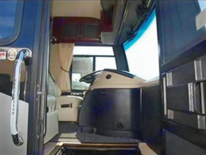 Spacious RV rental interior: view from entrance, showing driver's cabin, steering wheel, and living area with cabinets.. Fleetwood Revolution
