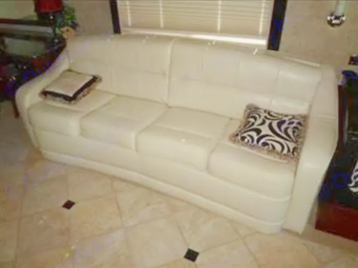 This comfortable white leather sofa enhances the living space of an RV rental. Features accent pillows and a tiled floor.. Fleetwood Revolution