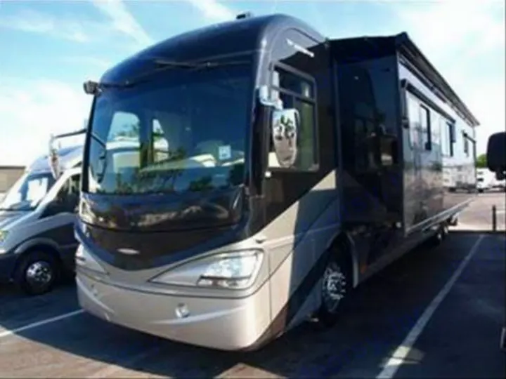 A large, two-tone black and tan luxury RV motorhome is parked, with its side slide-out extended. Perfect for rv rental!. Fleetwood Revolution