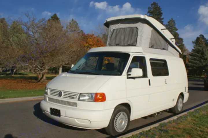 White pop-top camper van parked outdoors, perfect for an RV rental adventure or road trip travel.. Volkswagen Eurovan Full Camper 1997