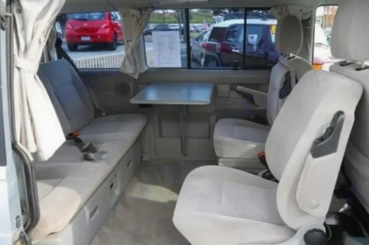 Inside this versatile RV rental, a bench seat with storage and a fold-out table complements two rotating chairs for comfortable travel.. Volkswagen Eurovan MV 2002