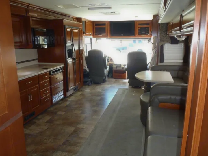 Spacious RV rental interior featuring a full kitchen, comfortable dinette, and front driver's area.. Fleetwood Discovery