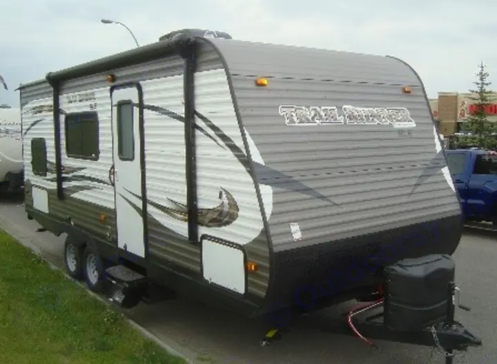 A grey and white Trail Runner travel trailer RV, ready for rv rental. Features an awning, windows, and dual axles.. Heartland Trail Runner 2017