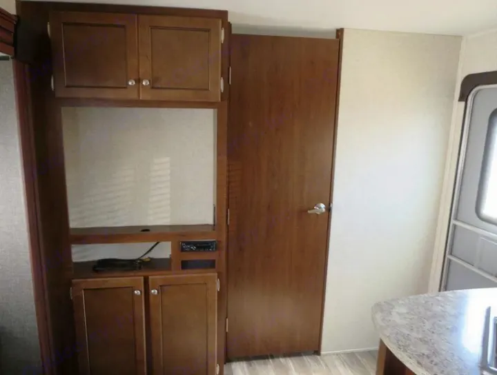 RV rental interior: Built-in cabinets, entertainment area, and a door for privacy. Perfect for your next adventure.. Heartland Trail Runner 2016