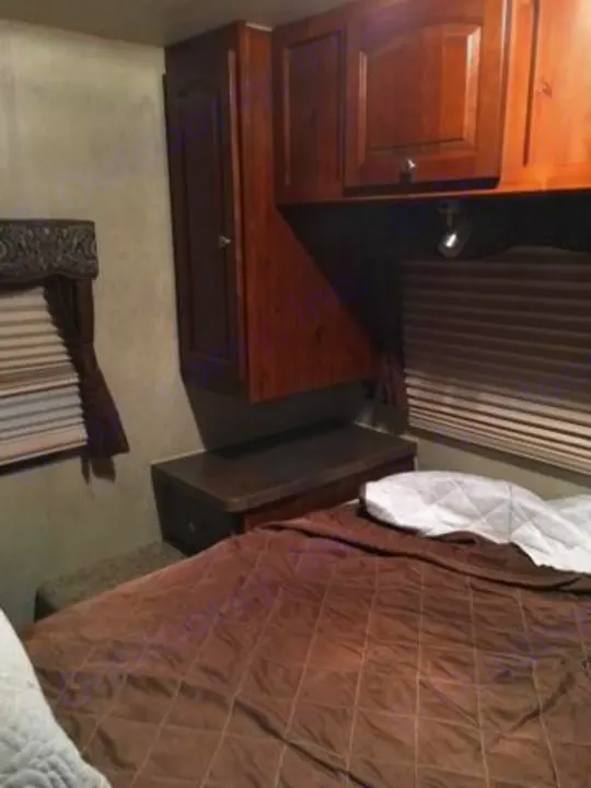 Front bedroom with Queen bed, bed side table and hanging closet on both sides. Forest River Rockwood Signature 2013