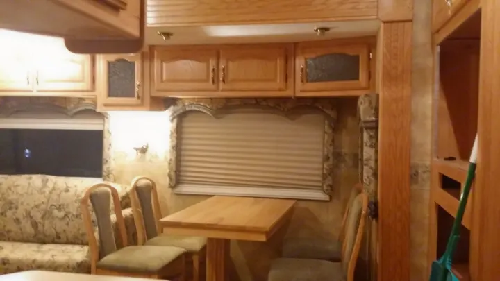 RV rental: RV interior with ample wood cabinets, a floral sofa, and a dining table with chairs.. Keystone Challenger 2005