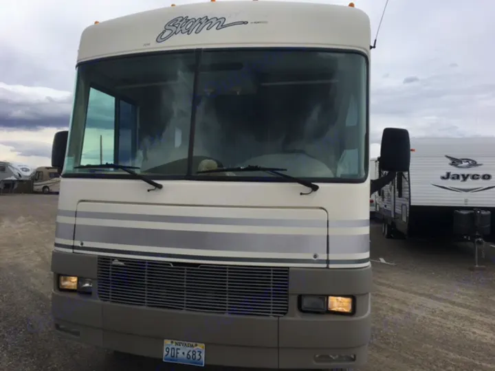 Front view of a two-tone Class A Storm motorhome, ideal for rv rental and travel adventures. Parked in a lot.. Fleetwood Other 2000