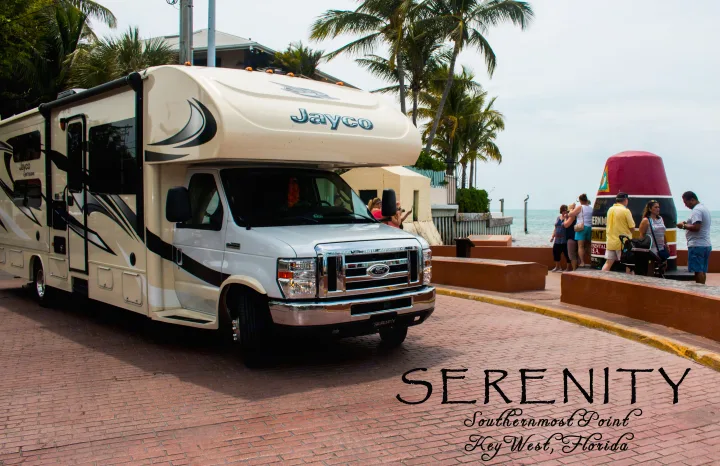 A white Jayco RV rental, named "Serenity," parked near Key West's iconic Southernmost Point buoy.. Jayco Greyhawk 2016