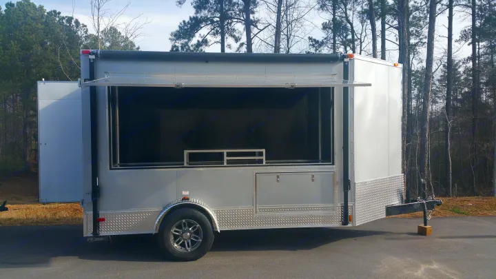 Silver concession trailer, ideal for RV rental or mobile catering, with open serving window & rear access for events.. Ready 2 Roll Party Central 2021