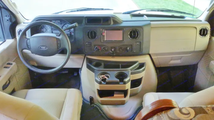 RV rental cockpit view: Ford E-Series dashboard, showing steering wheel, infotainment screen, and central console.. Forest River Sunseeker LE 2015