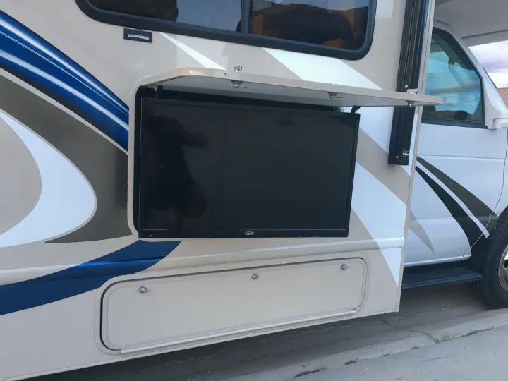 This **RV rental** features a built-in outdoor TV setup, perfect for campsite entertainment. Side storage visible.. Other Other 2018