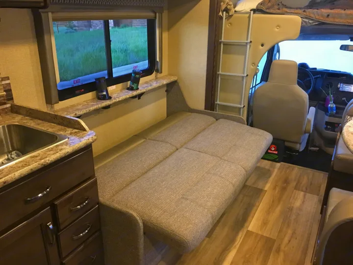 RV rental interior: View of the comfortable living area with a convertible sofa, kitchen sink, and overhead bunk.. Other Other 2018